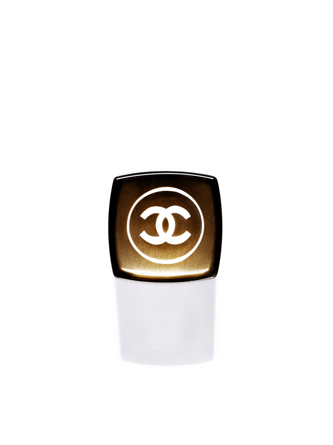 Black and gold lipstick cap with the interlocking CC emblem on a white background, for Chanel.