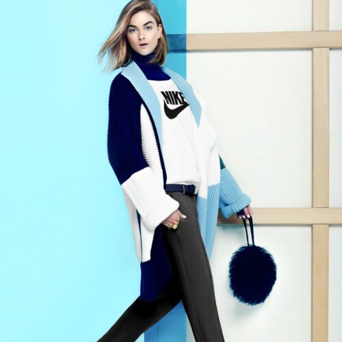 Model in a navy, white and blue colour-block cardigan over a Nike sweatshirt, carrying a black fur bag, for Lucky.