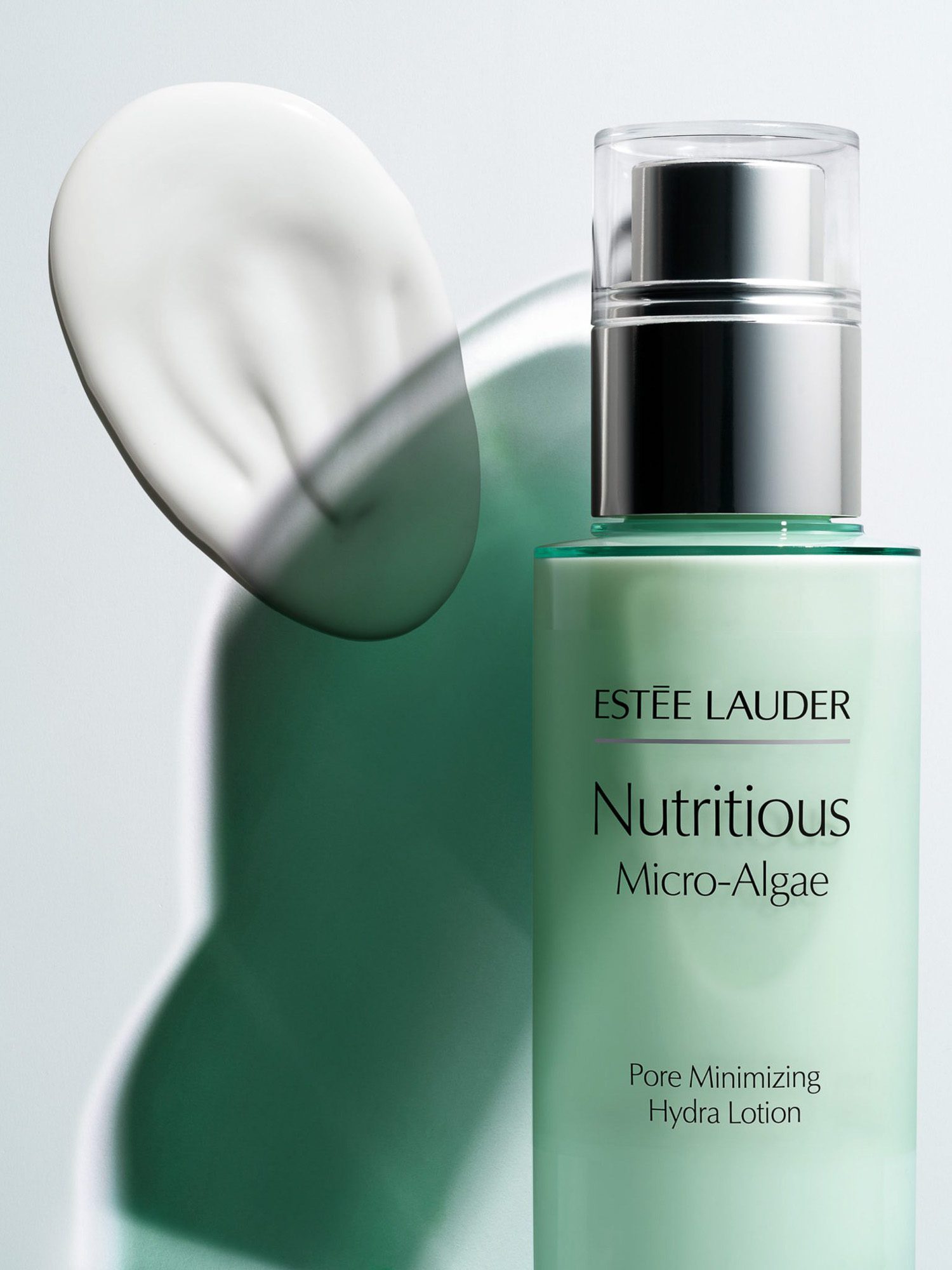 Mint-green Nutritious Micro-Algae lotion bottle with silver pump beside a white cream swatch and green shadow, for Estée Lauder.